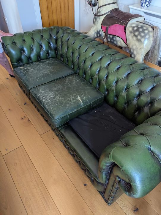 Green leather Chesterfield before, with cracked and worn seat cushions