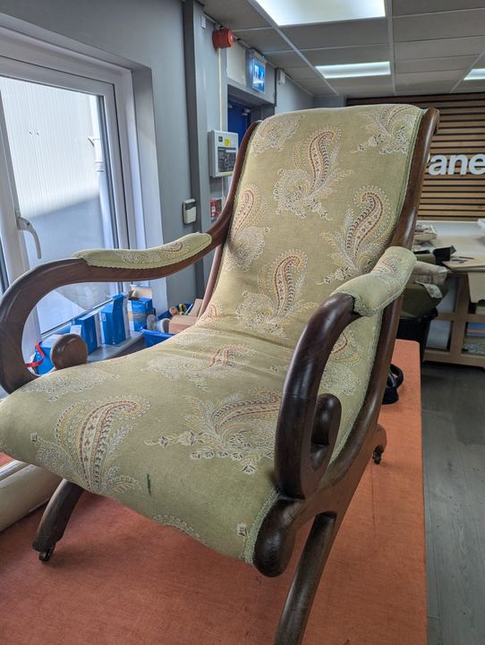 Scroll-arm chair before, in a faded green paisley